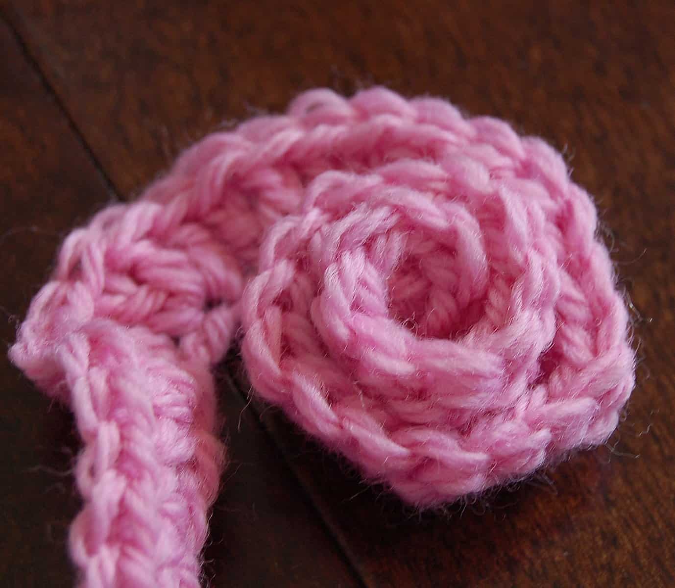 Wrap the pink crochet spiral around and around to form the small crochet rose.