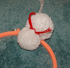 One small snowman laying on embroidery hoop.