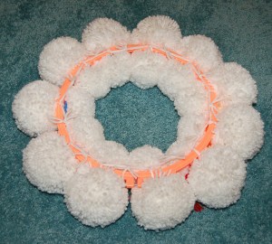 The backside of the yarn pom wreath showing how all snowmen are attached.