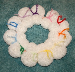 The front side of the yarn pom wreath after all snowmen are attached.