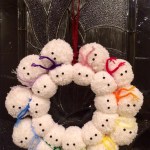 Snowmen crochet pom wreath with chain scarves.