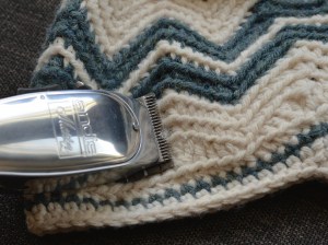 Silver clippers shaving fuzz off crochet newsboy.