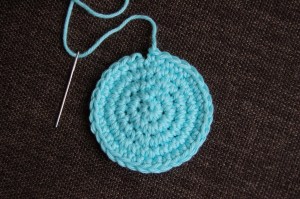 Small blue circle with yarn needle to complete invisible join.