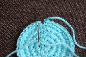 Yarn needle and light blue swatch to show how to work an invisible join in crochet.