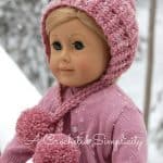 American girl doll modeling pink winter crochet hat with yarn poms.