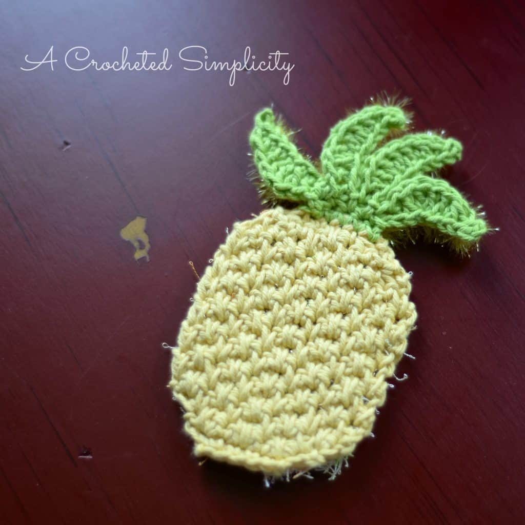 Pineapple crochet scrubby made with yellow and green cotton yarn.