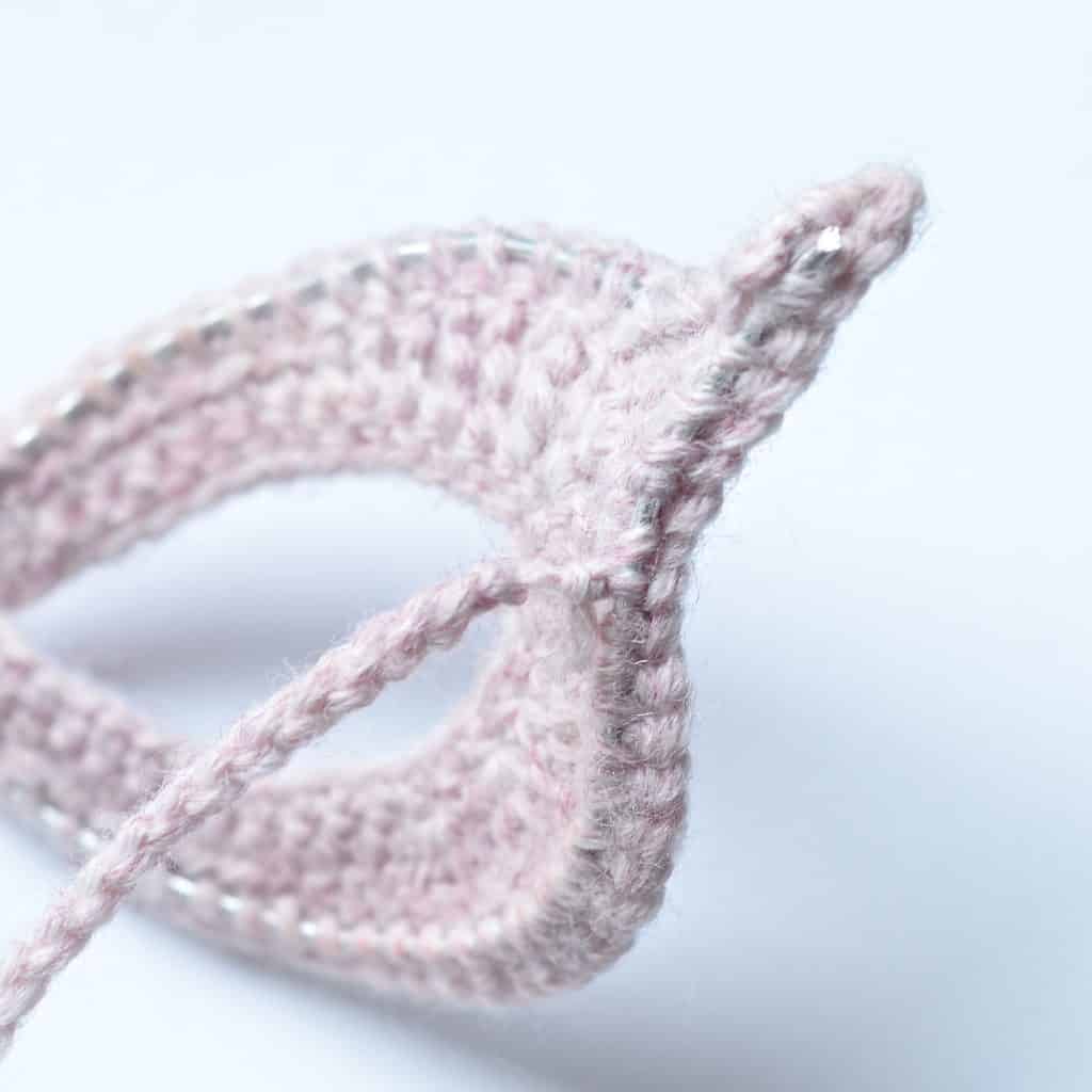 Half of pink super hero crochet mask.