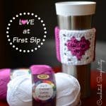 Medium pink and white crochet coffee sleeve with a granny stitch heart.