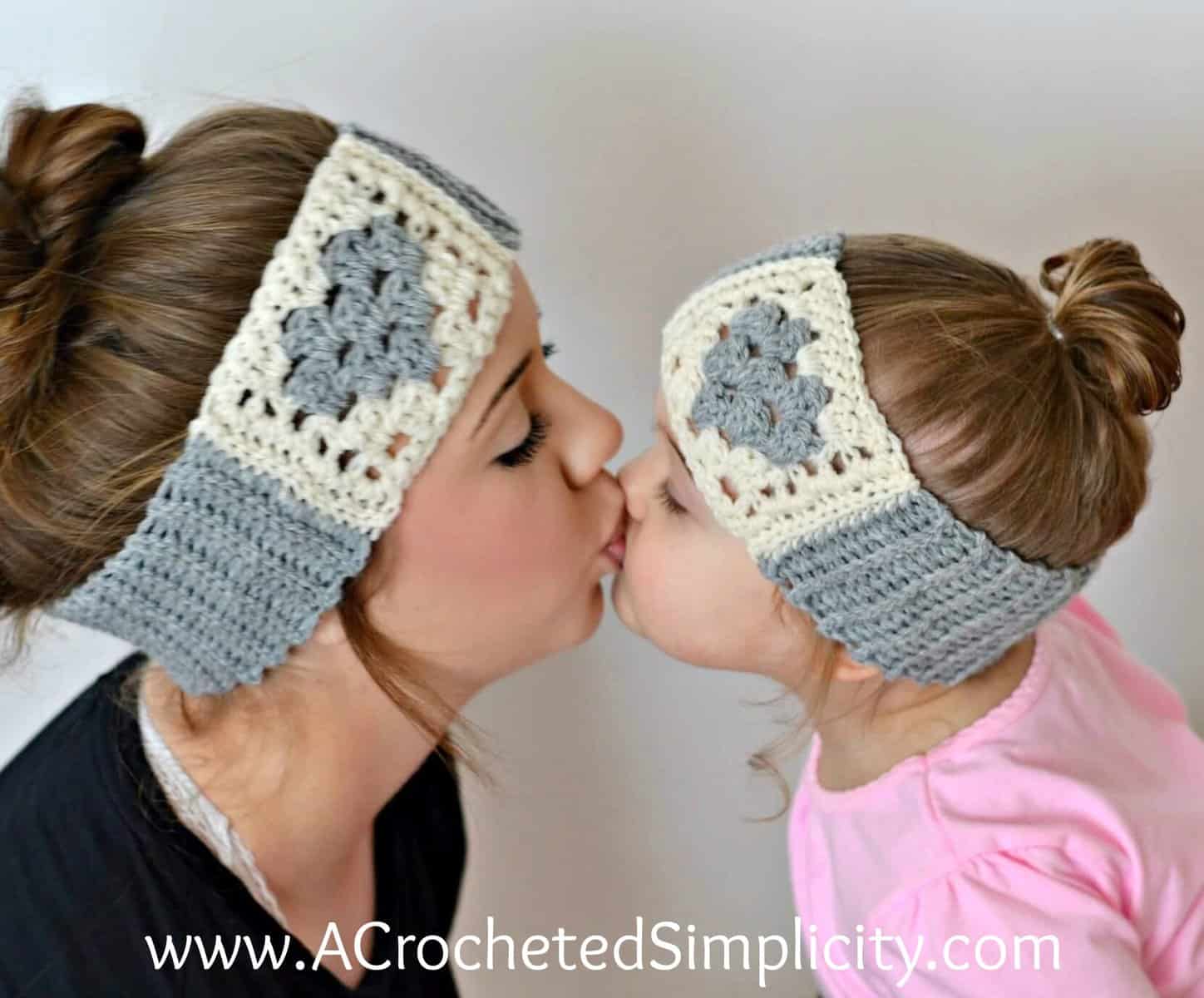Sisters wearing cream and medium grey crochet ear warmers with hearts in granny stitch.