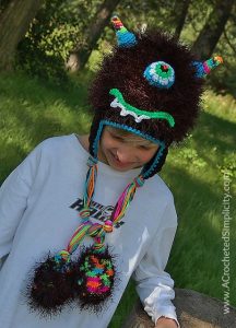 Boy wearing black furry monster hat with one big eye.