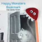 Red crochet monster bookmark on cat book.