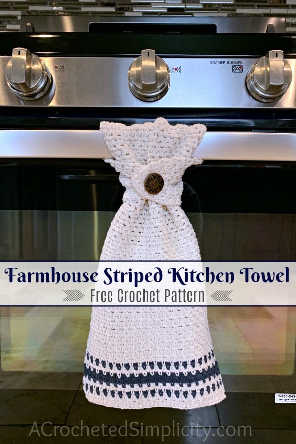 Ecru and navy crochet dish towel with a button hanging on an oven door handle.