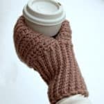 Knit look crochet drink mitt holding a thermal cup of coffee.