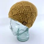 gold argyle messy bun hat on glass head stand