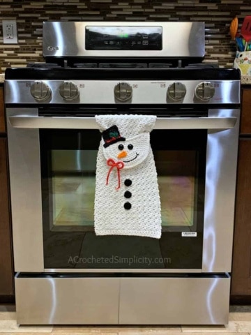 Free Crochet Pattern - Snowman Kitchen Towel by A Crocheted Simplicity #snowmantowel #freecrochetpattern #crochetdishtowel #crochetteatowel #crochetkitchentowel #christmastowel #christmascrochet #snowman #crochetsnowmman