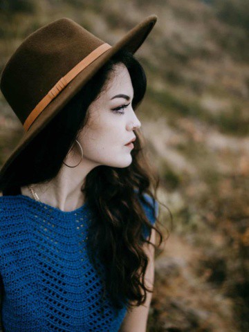 Side profile view of a woman modeling a knit look crochet summer top.