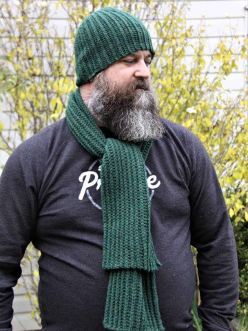 Man with beard wearing a green ribbed crochet scarf and beanie set.