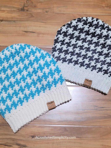 Two crochet houndstooth slouch hats laying on one floor.