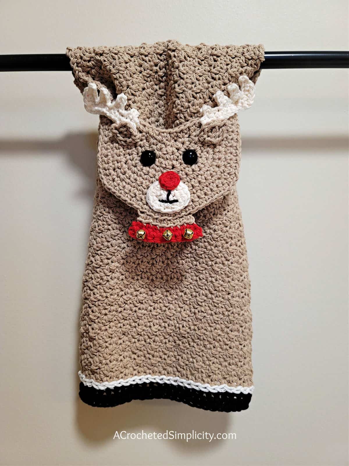 Reindeer crochet dish towel hanging on towel bar.