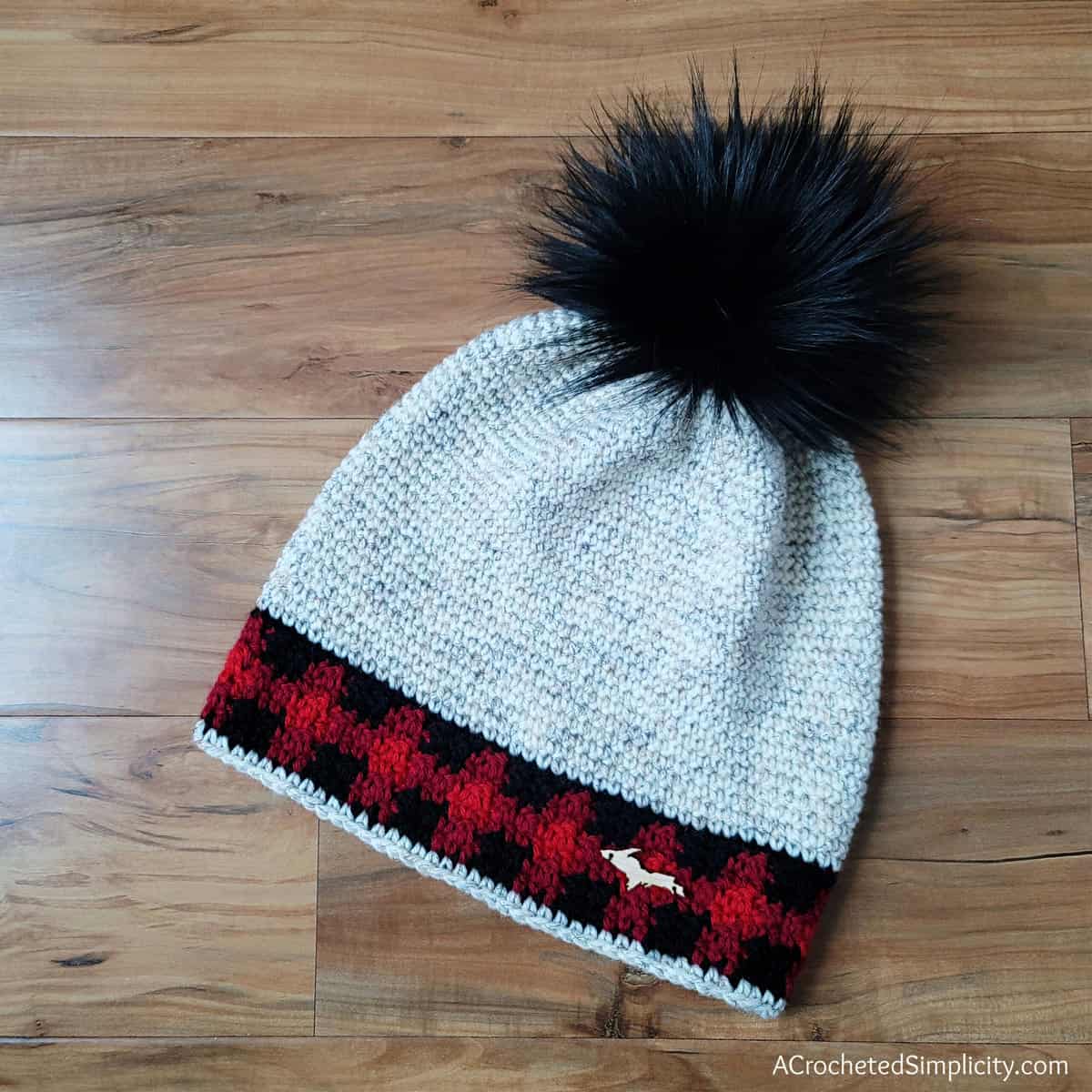 Single crochet beanie with plaid accents and big black faux fur pom.