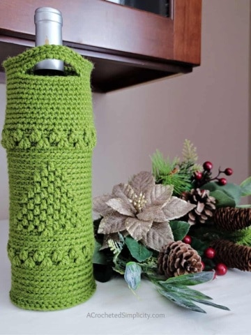 Free Crochet Wine Tote Pattern - O' Christmas Tree Wine Tote by A Crocheted Simplicity. #crochetchristmas #handmadechristmas #crochetwinetote #crochetwinecozy #winetote #winecozy #christmaswinetote #crochetchristmaswinetote #crochetchristmastree #freecrochetpattern #winetotepattern #crochetwinetotepattern #lastminutecrochetgifts