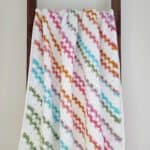 Crochet corner to corner afghan hanging on a blanket ladder.