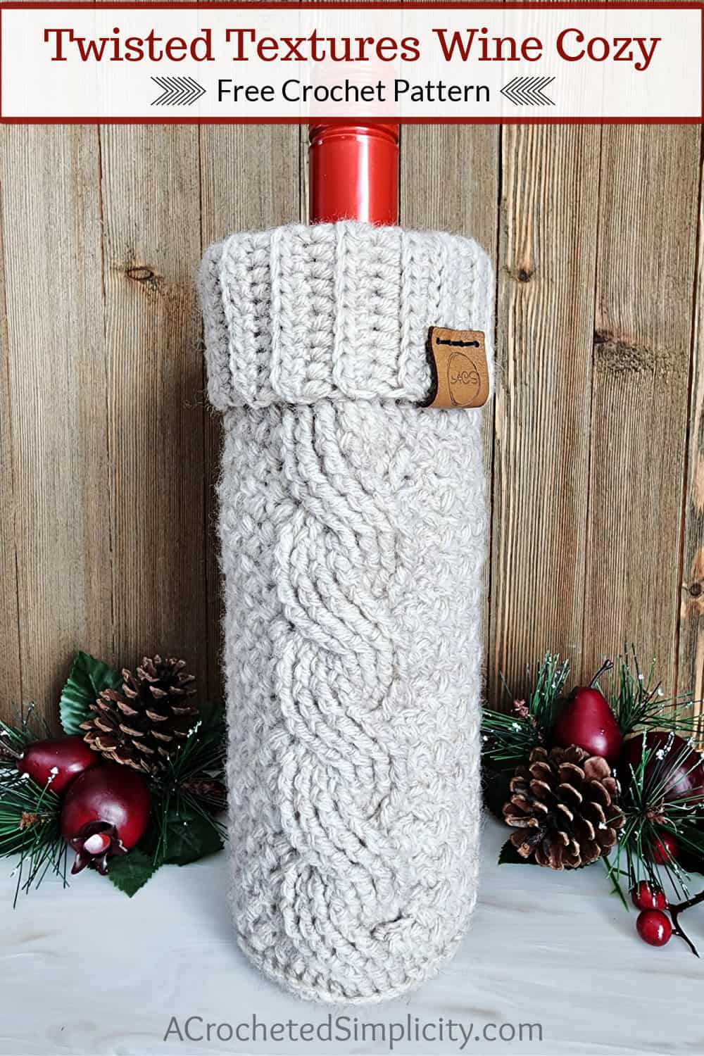 A taupe crochet wine cozy with a cable and ribbed cuff holding a bottle of wine.