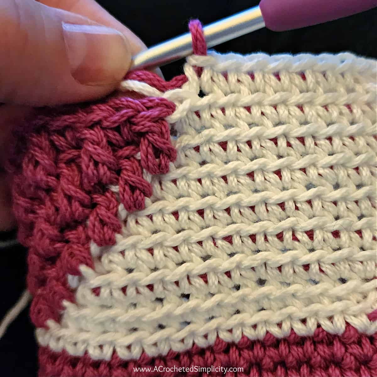 Close up of a crochet valentines treat bag showing how to change colors from white to pink.
