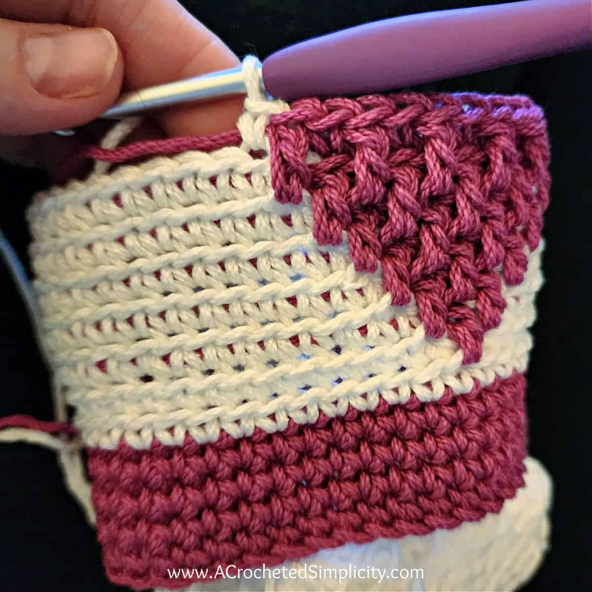 Close up of a crochet valentines treat bag showing how to change colors from pink to white.
