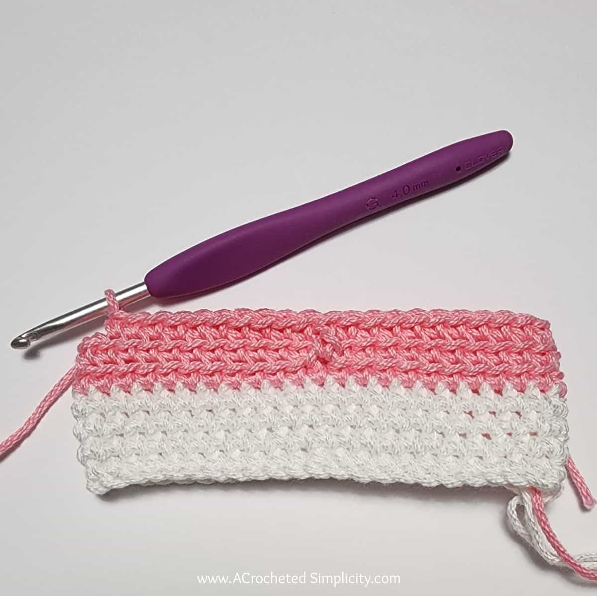 Crochet Valentine's Day treat bag tutorial photo in pink and white yarn showing round 1 complete.