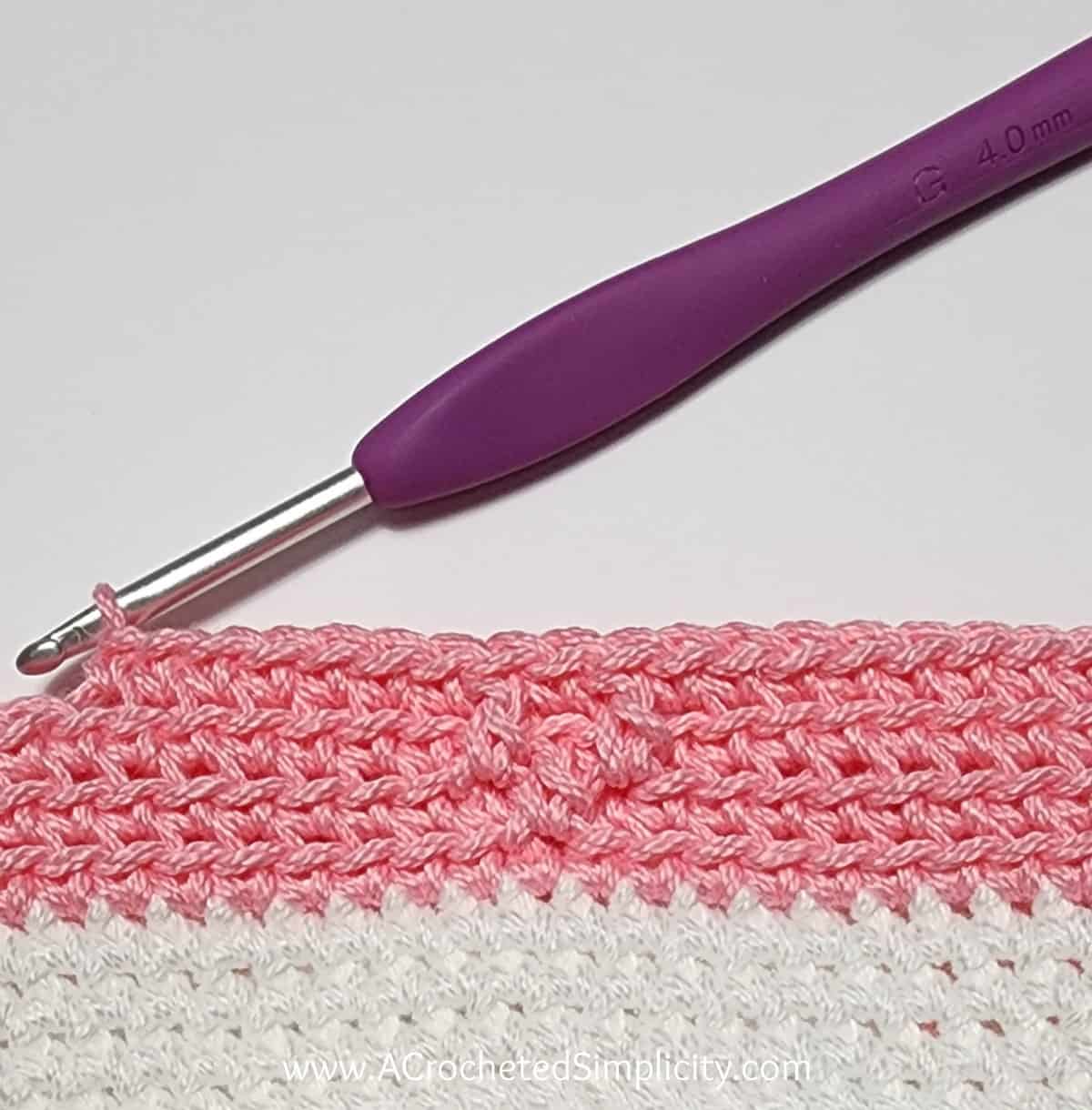 Crochet Valentine's Day treat bag tutorial photo in pink and white yarn showing round 2 complete.