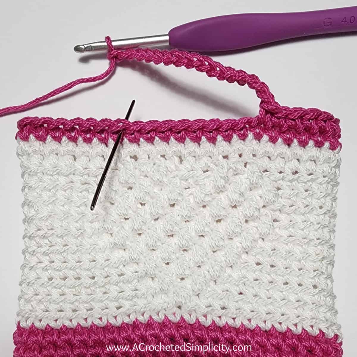 Pink and white crochet heart treat bag with small handle.