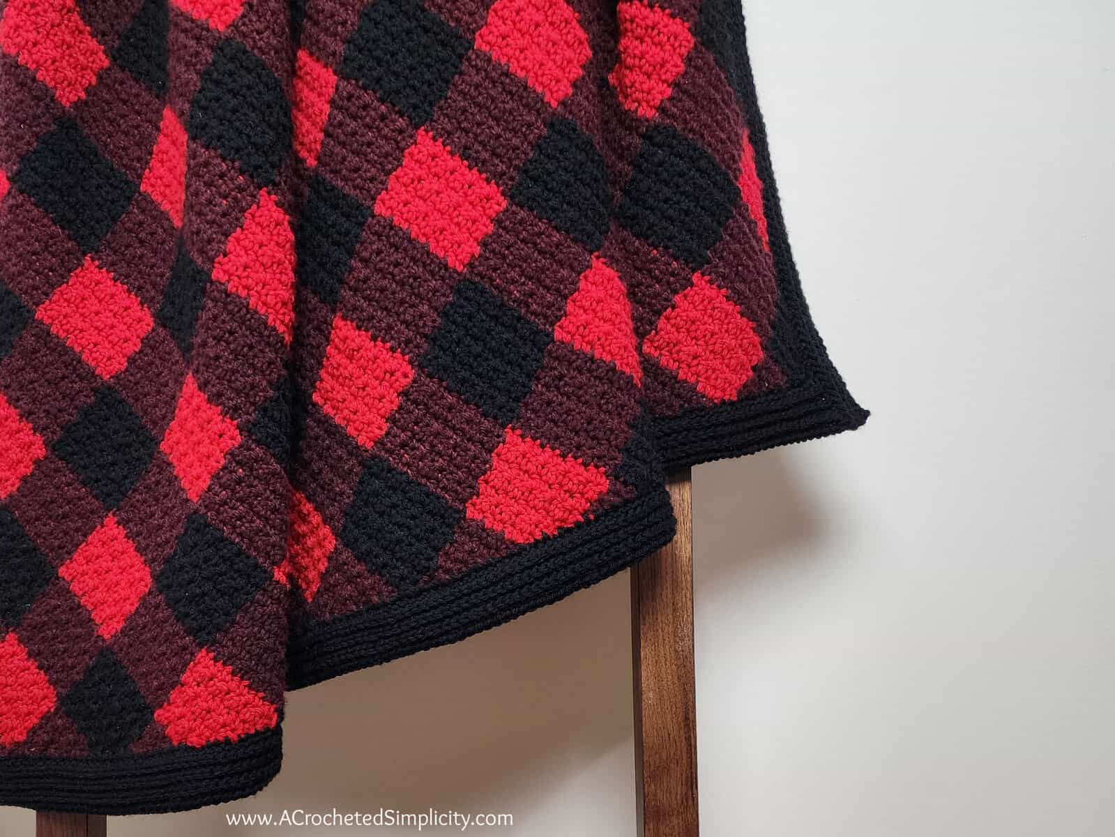 Red and black buffalo plaid blanket hangin on blanket ladder.