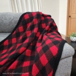 Close up of crocheted buffalo plaid blanket draped over the couch.