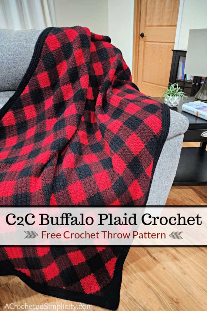 Traditional red and black crocheted buffalo plaid blanket draped over a couch.