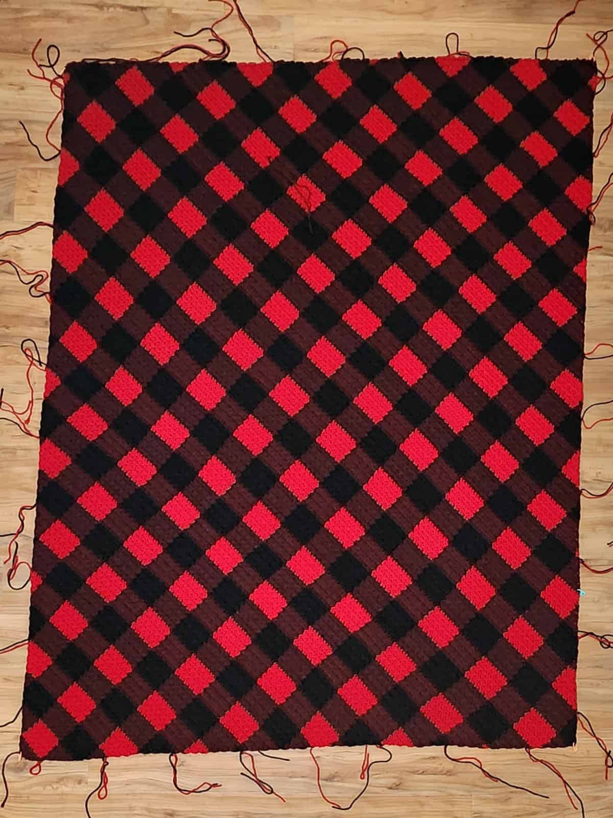 This image shows the main portion of a red and black buffalo plaid corner to corner blanket complete before adding a border.