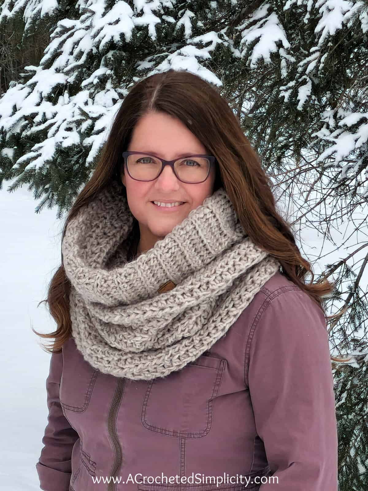 Woman in brown jacket wearing crochet cowl.