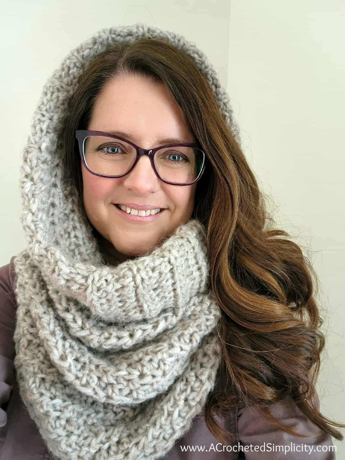 Close up of a girl wearing a hooded crochet cowl with a wide cuff.