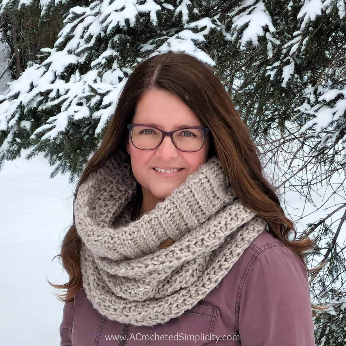 Close up of woman outside wearing chunky crochet hooded cowl.