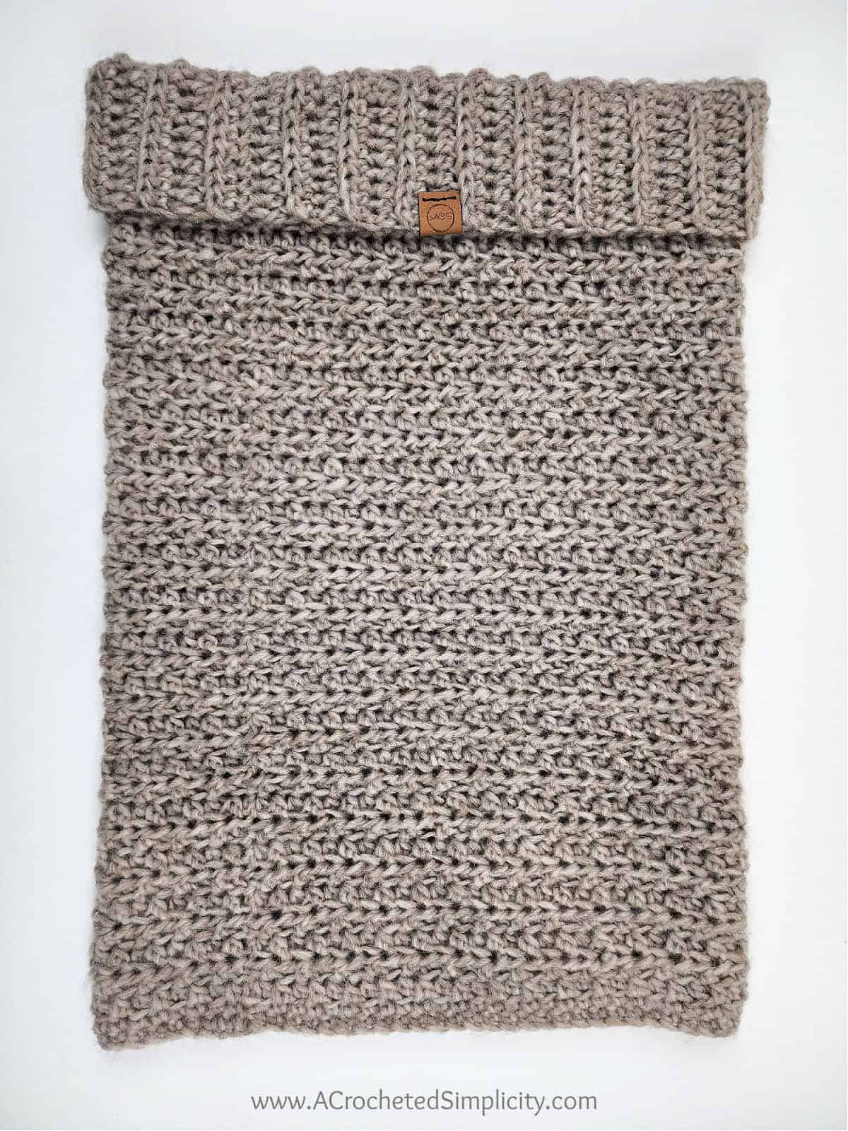 This image is over the easy crochet hooded cowl laid out flat with the ribbed cuff folded down.