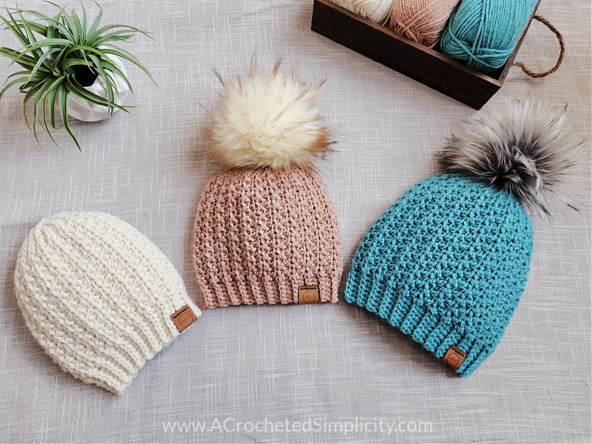 Three short row crochet hats laying with a small plant.