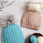 Two short row crochet hats laying with a wooden yarn bowl and small balls of yarn.