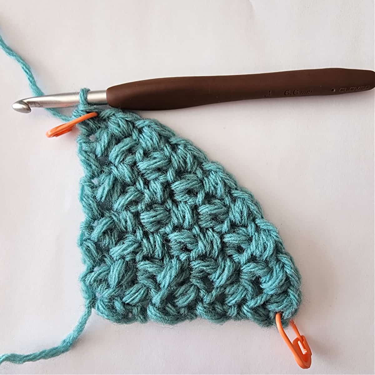 Crochet corner to corner mini bean stitch triangle swatch with eight rows.
