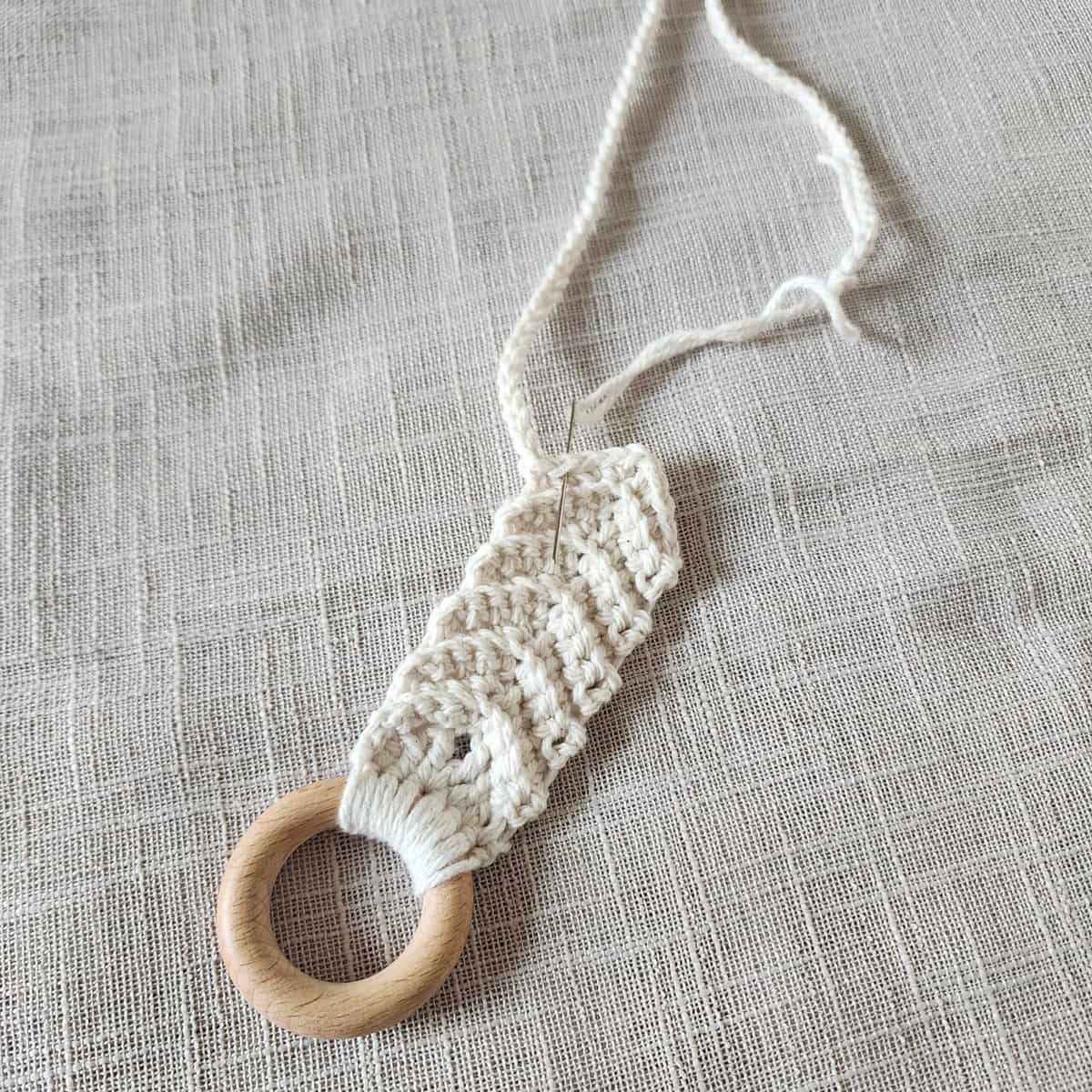 Crochet plant hanger being attached to hanging straps.