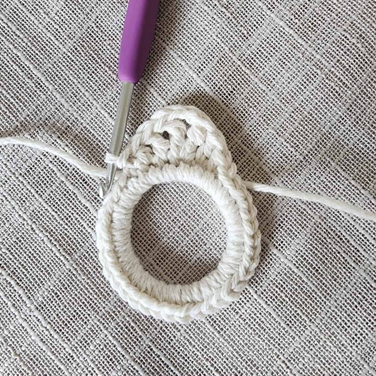 DIY plant hanger ring with milk jug ring and ecru yarn.