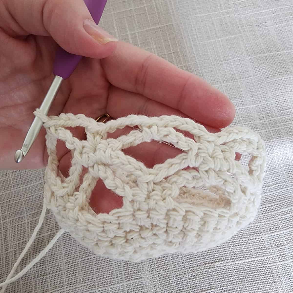 Cream yarn used to crochet lace on plant hanger basket.