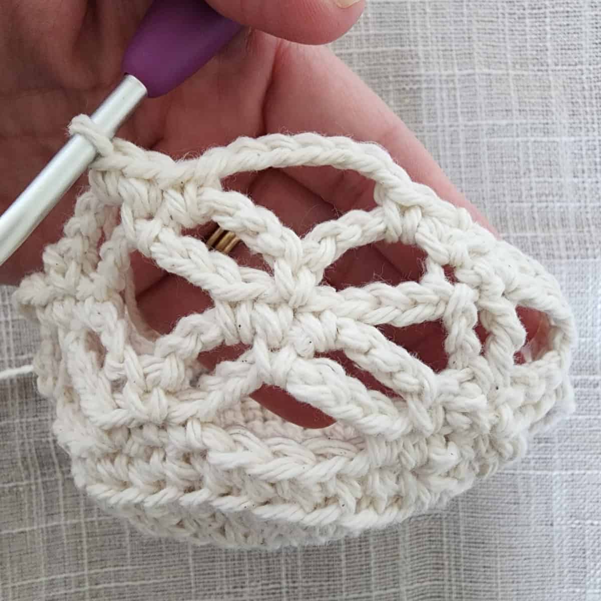 Crochet lace worked onto circle to form crochet plant hanger basket.
