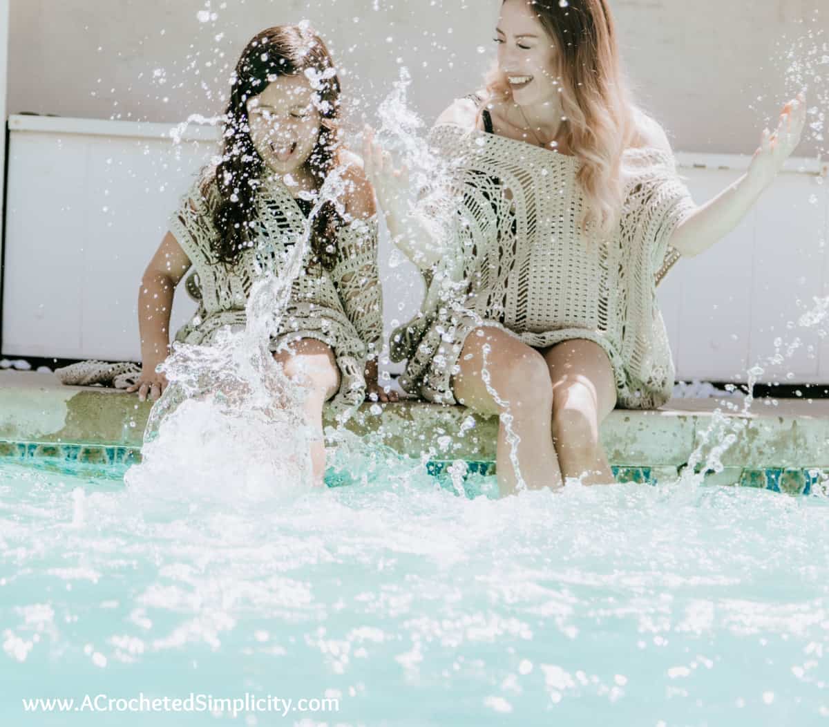 mom and daughter splashing while sitting on edge of pool in new crochet swim cover ups