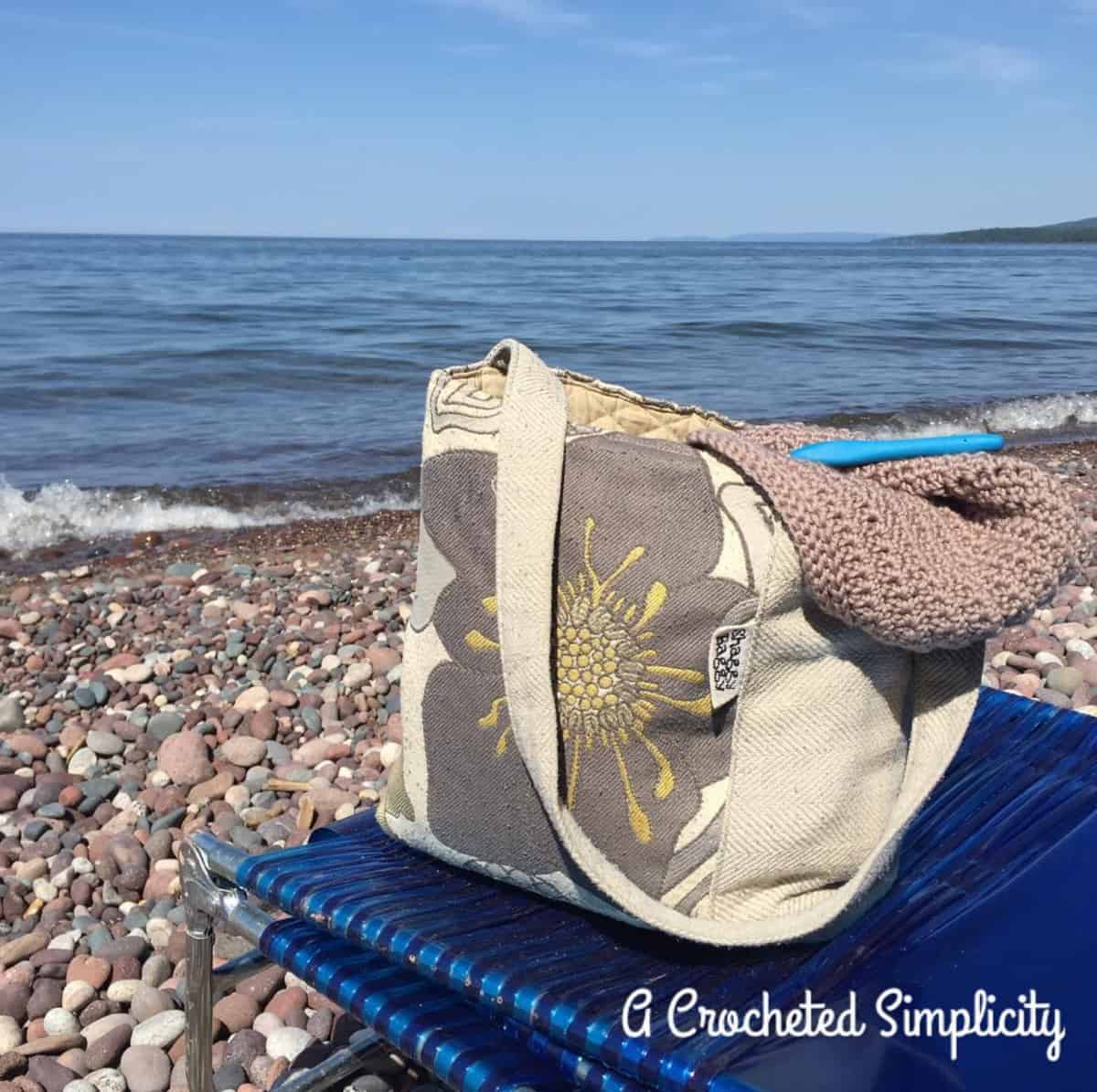 small crochet project bag on the beach