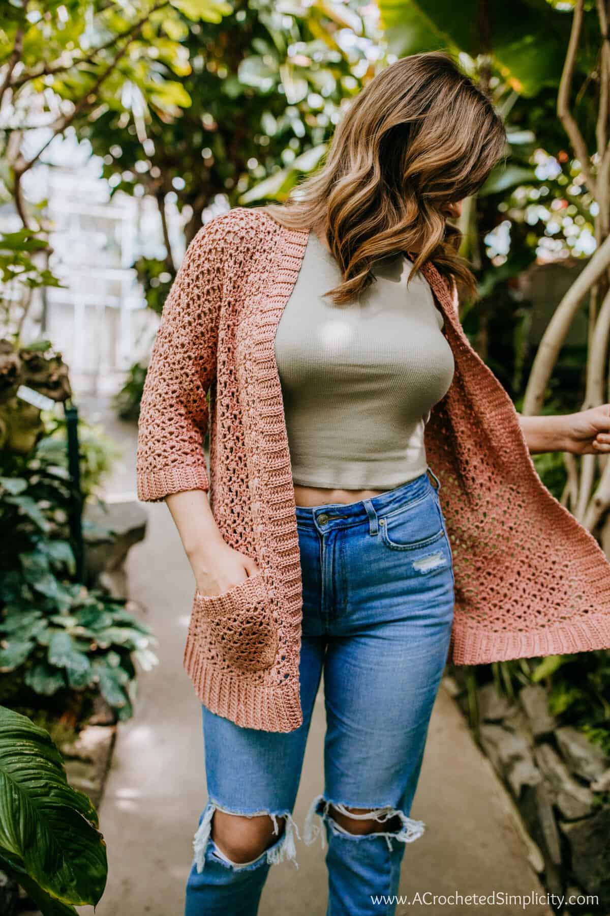 Woman wearing a mauve crochet summer cardigan.